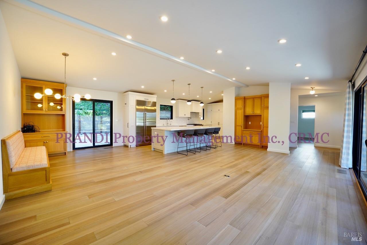 a view of a living room and kitchen with furniture wooden floor