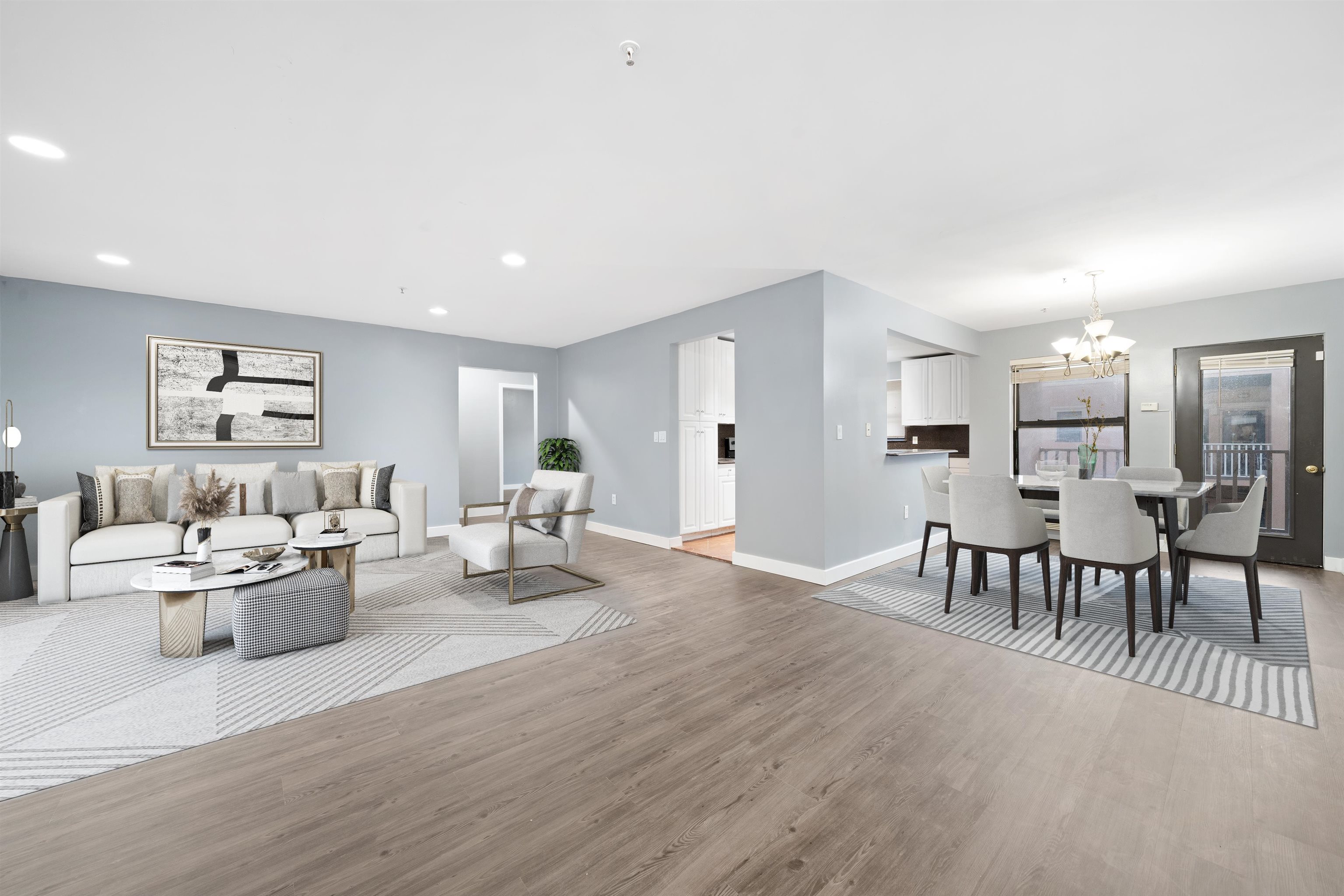 a living room with furniture and a dining table with kitchen view