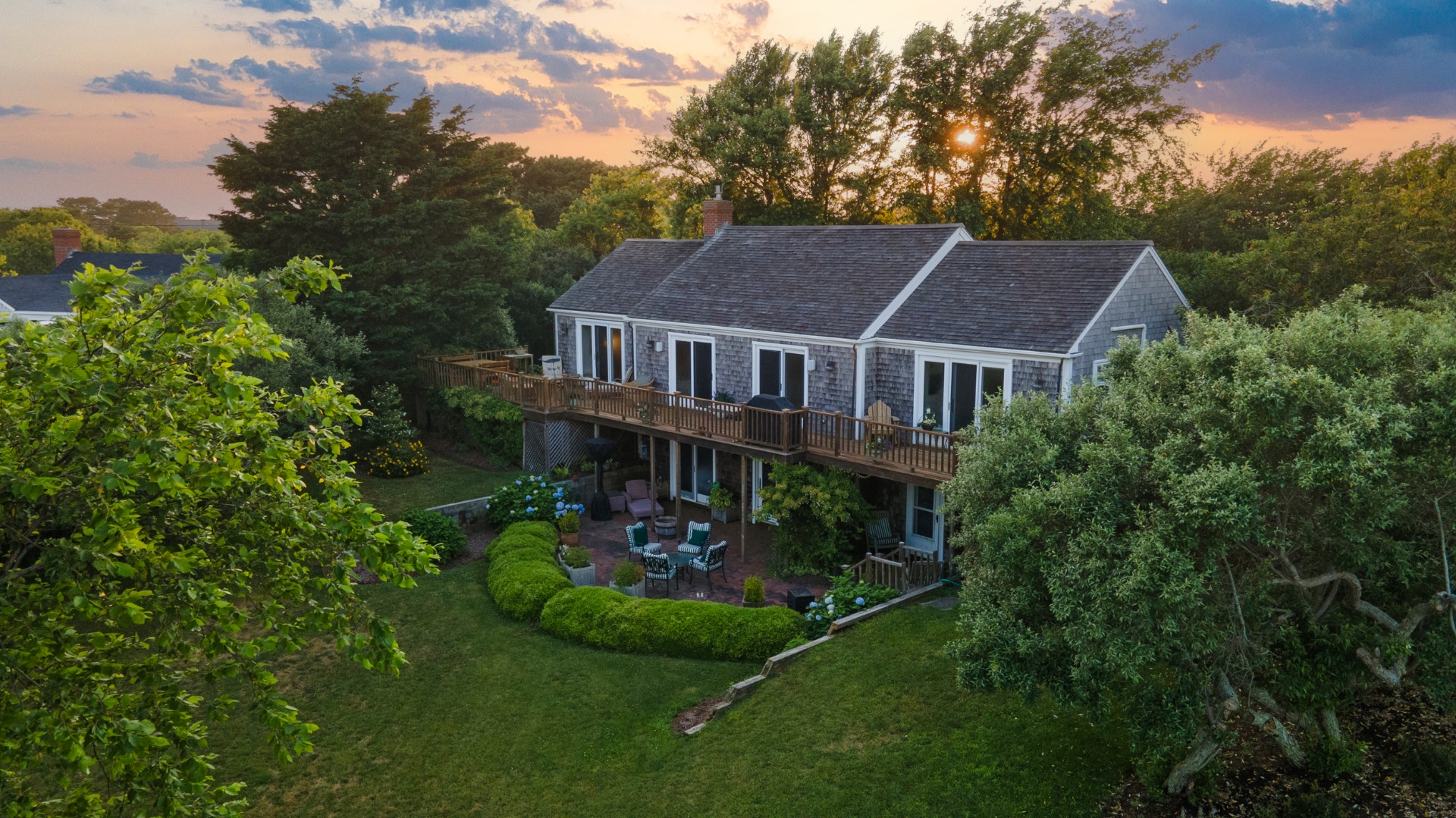 a aerial view of a house next to a big yard and large trees