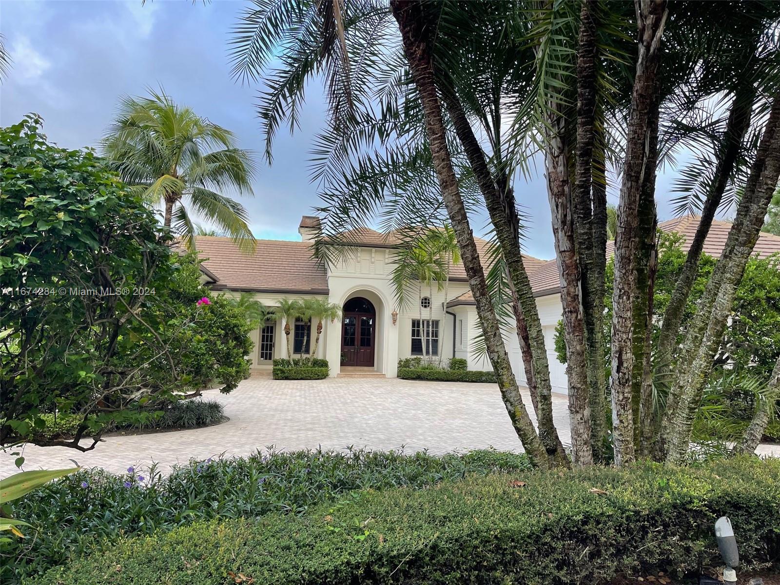 a front view of a house with a yard and trees