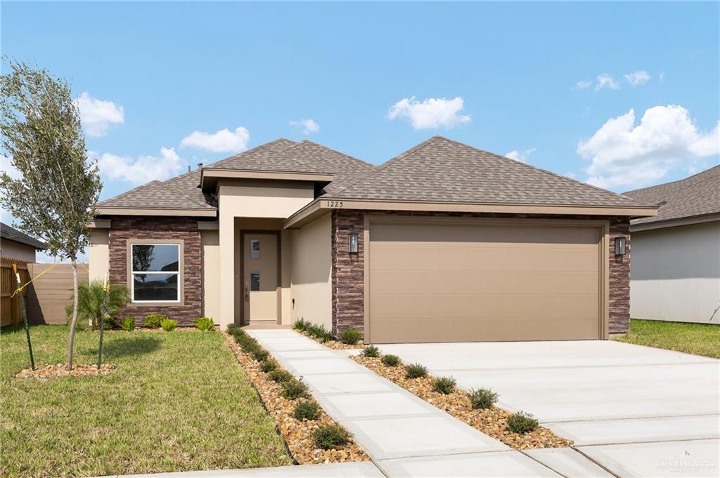 Prairie-style house featuring a front lawn and a garage