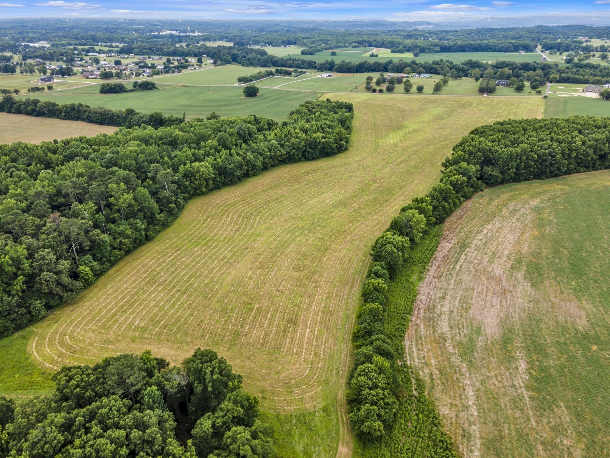 an aerial view of ocean with green space