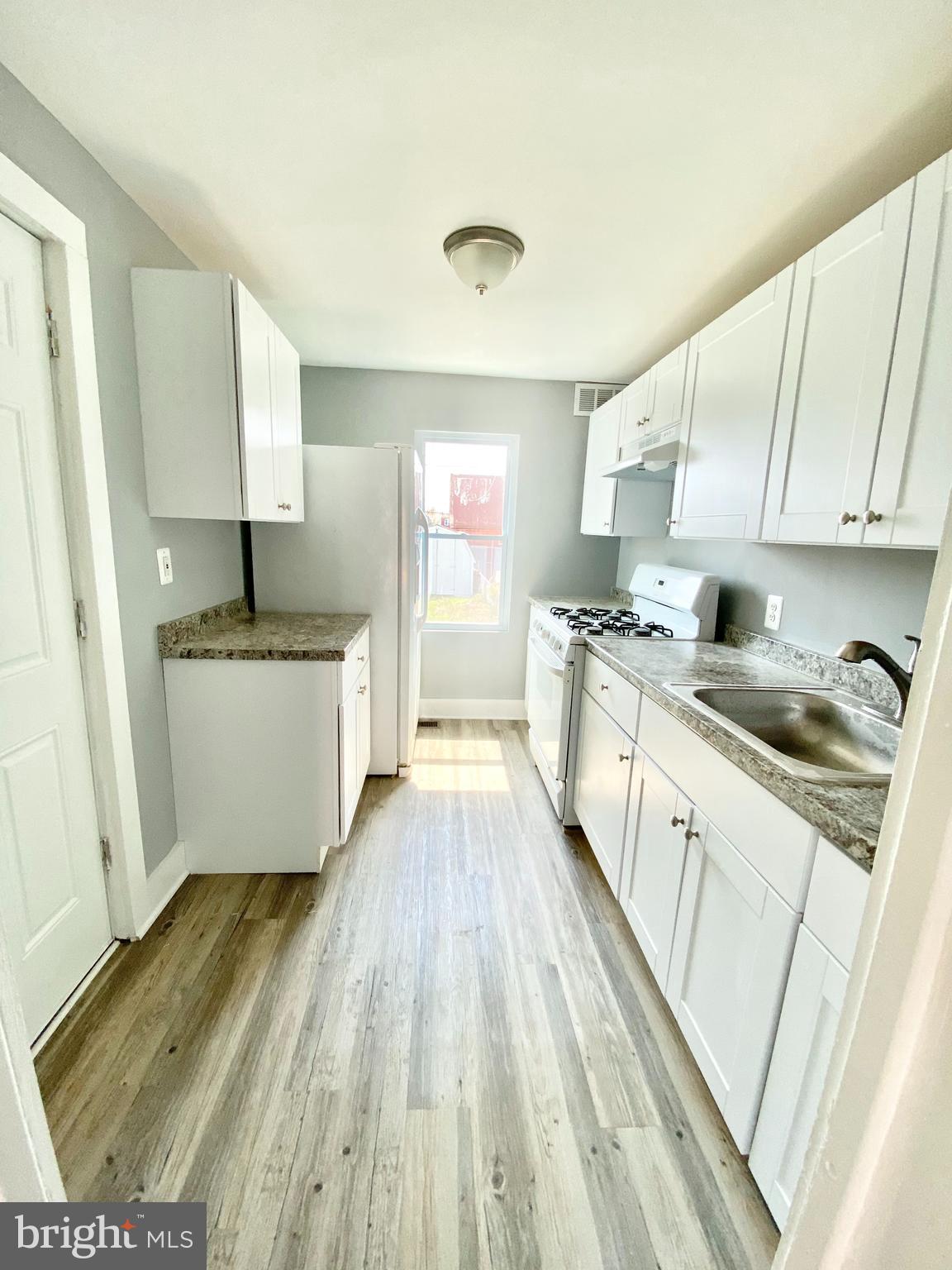 a kitchen with a sink a counter top space and cabinets