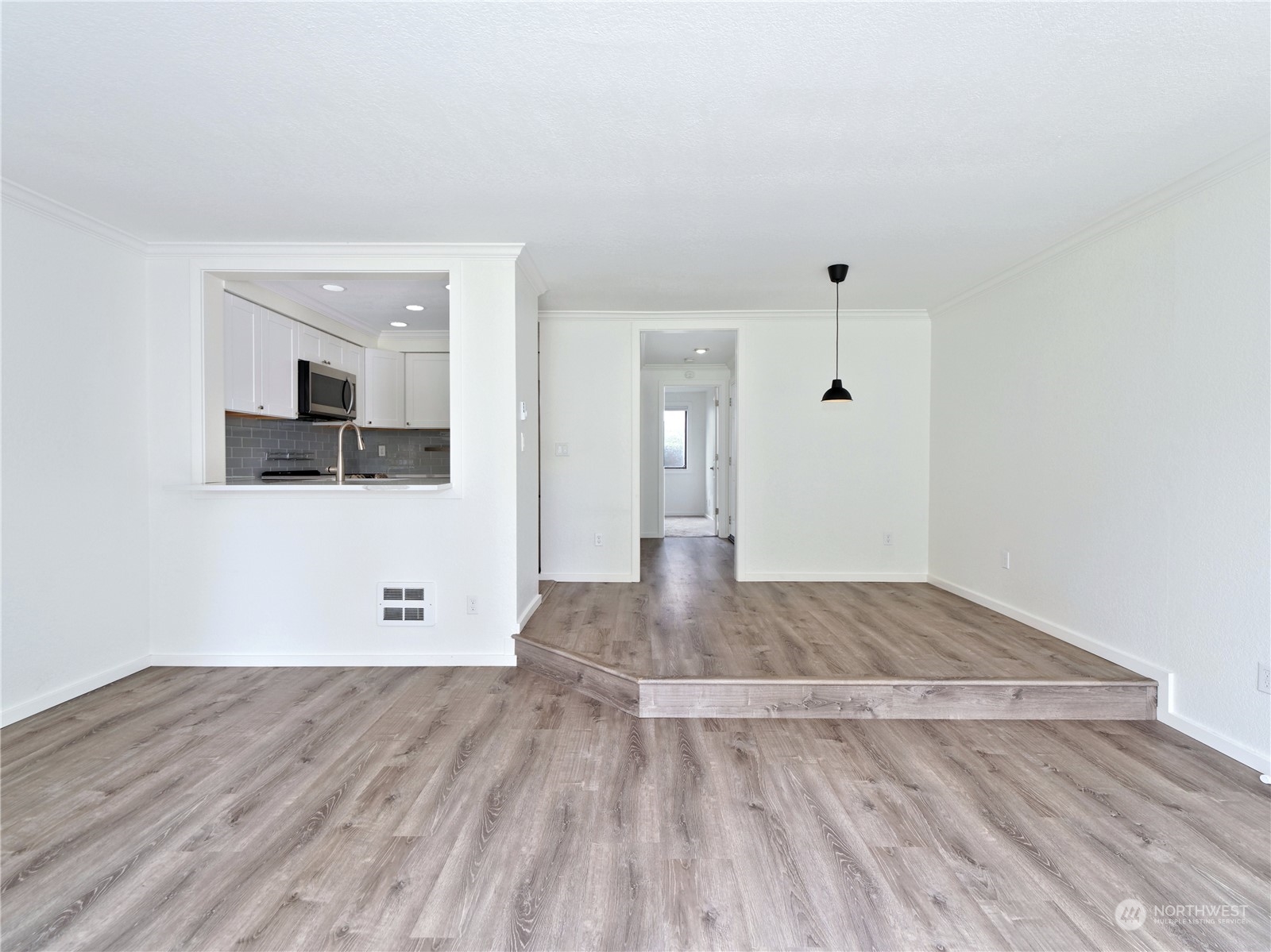 a view of empty room with wooden floor