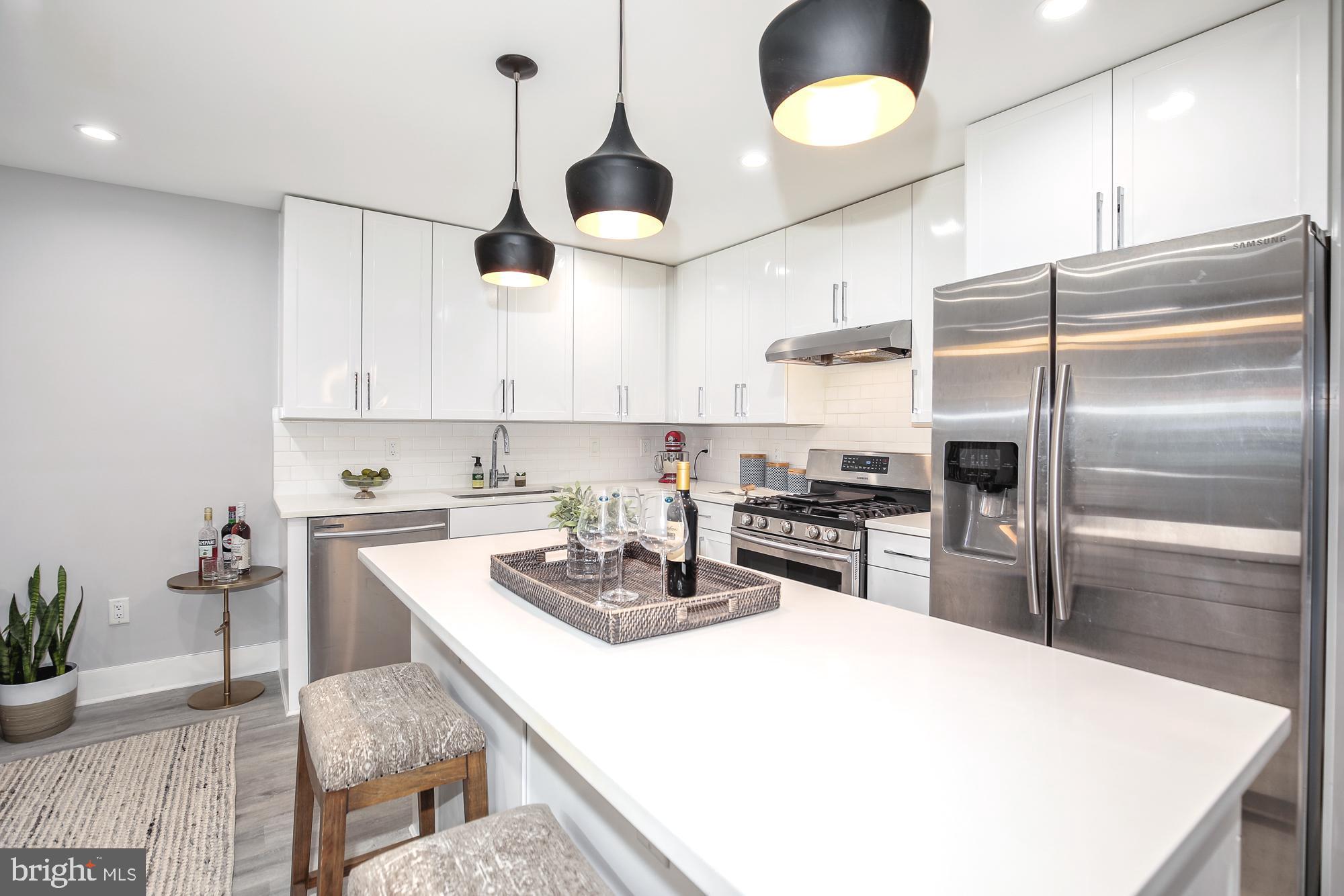 a kitchen with stainless steel appliances a table a sink and cabinets