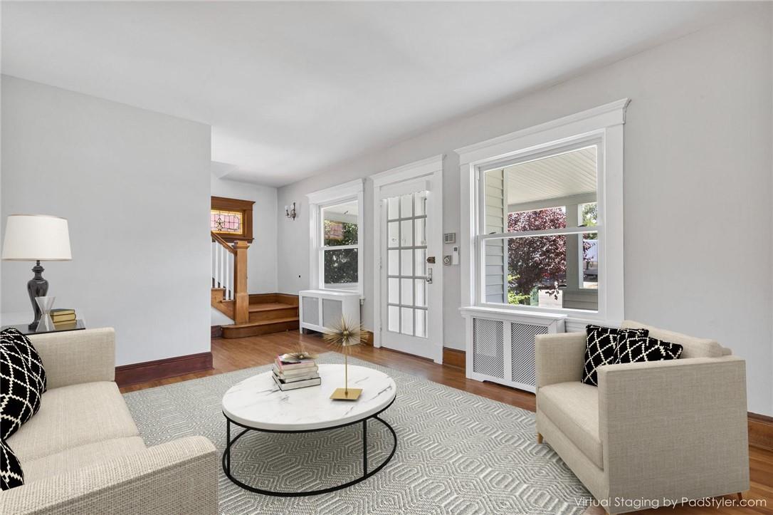 Virtually Staged. Living room with radiator and hardwood / wood-style flooring