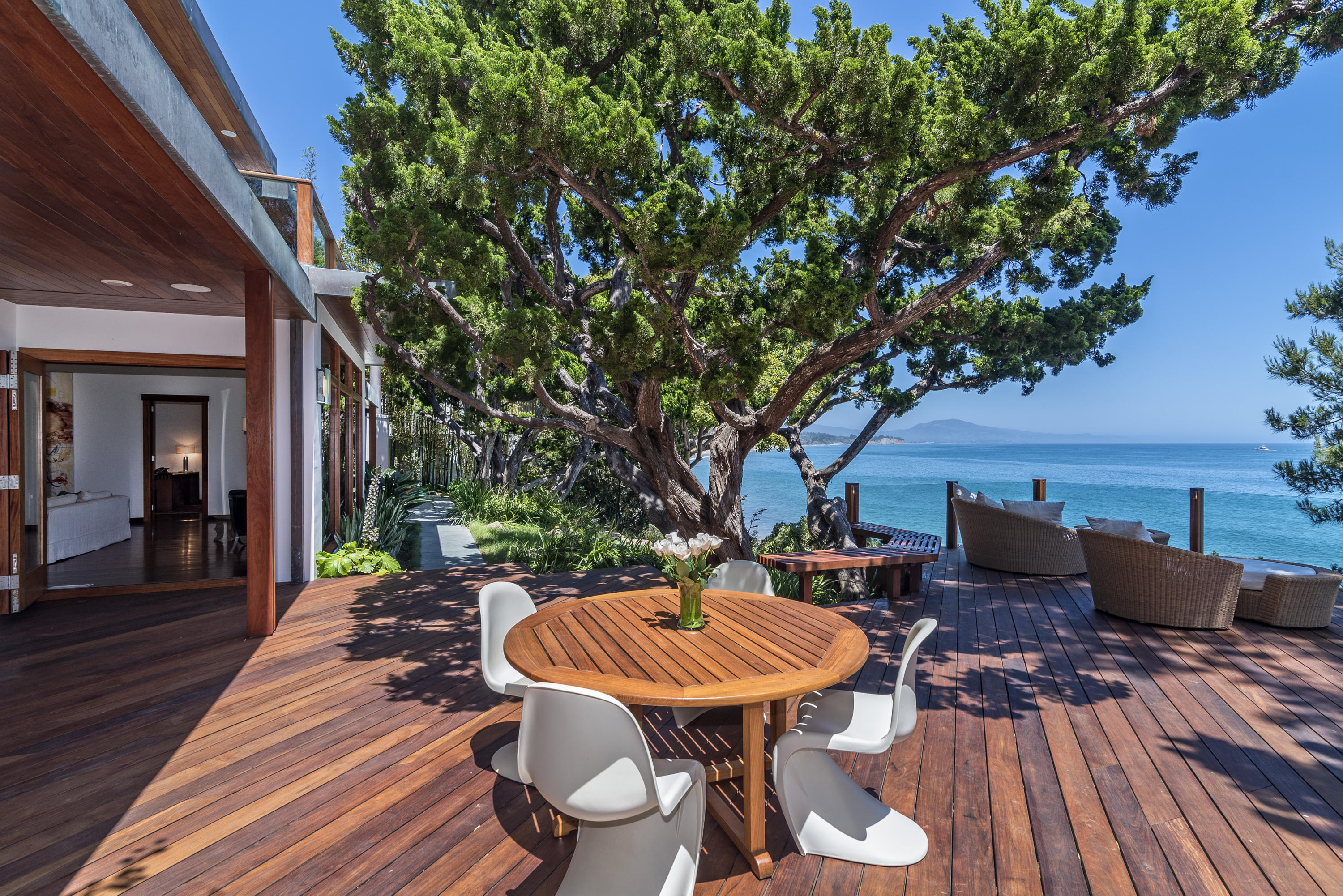 a backyard of a house with wooden floor table and chairs