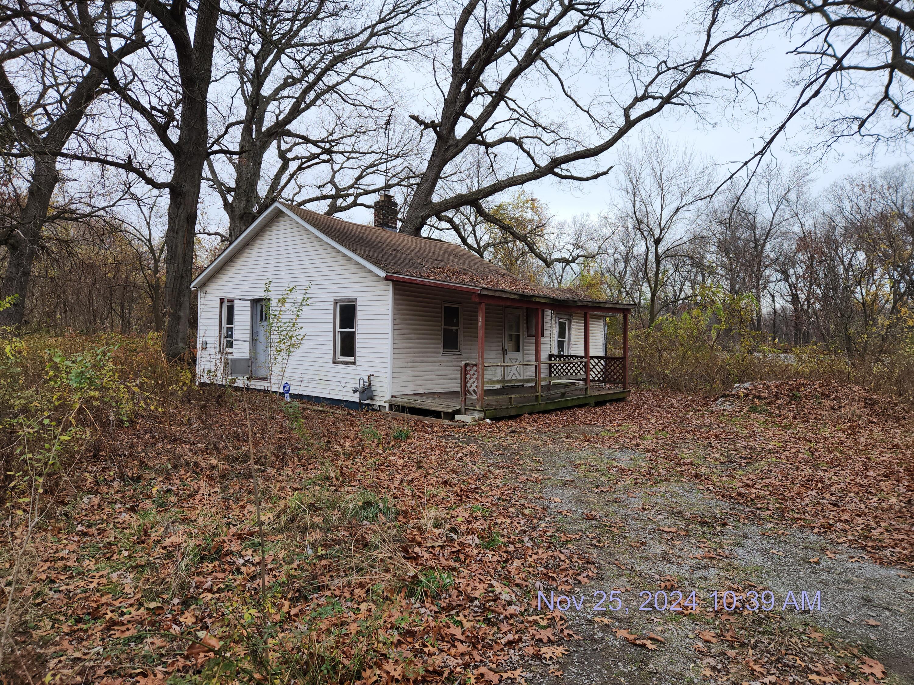 a view of a house with a yard and large tree