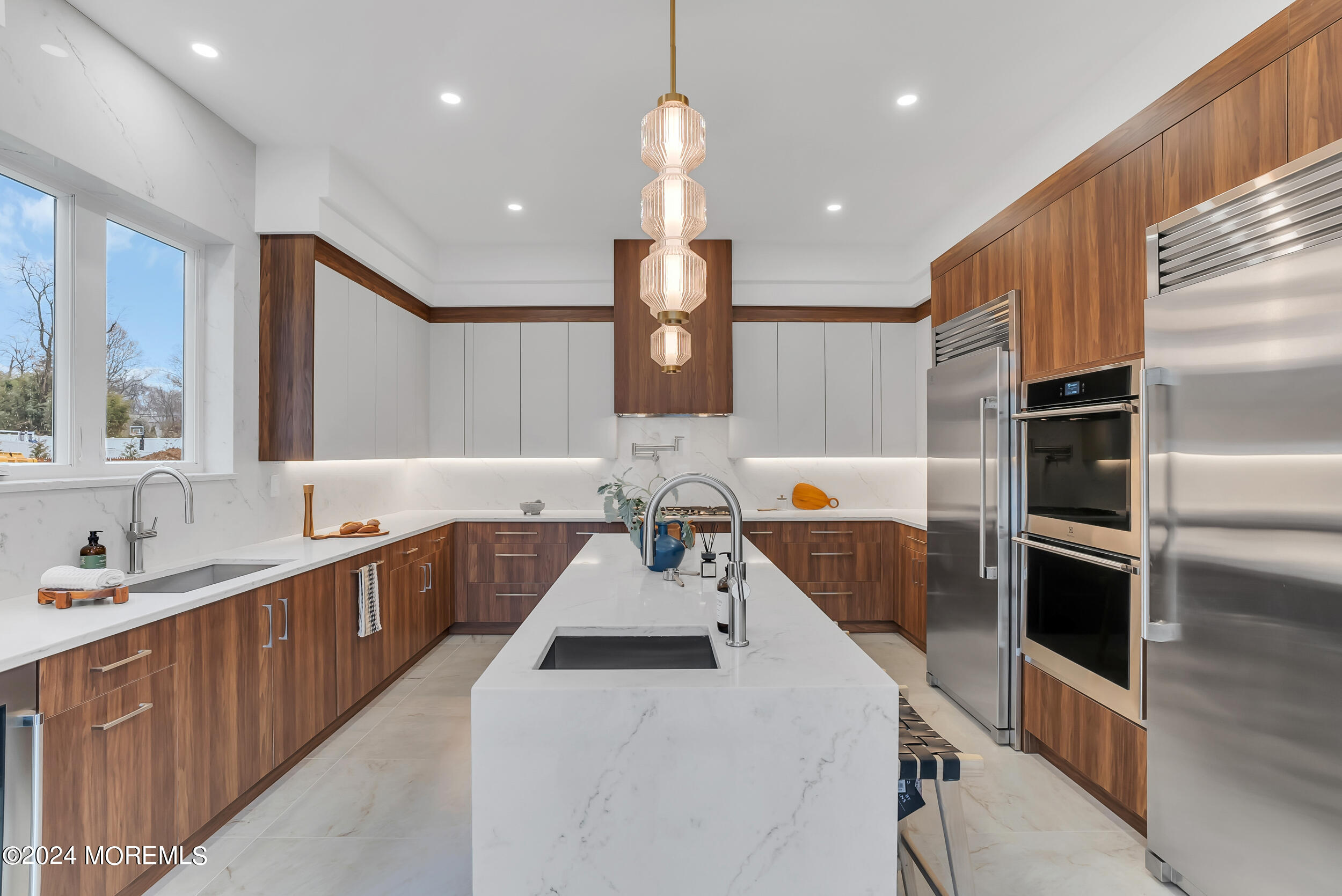 a large kitchen with kitchen island a large counter space a sink stainless steel appliances and cabinets