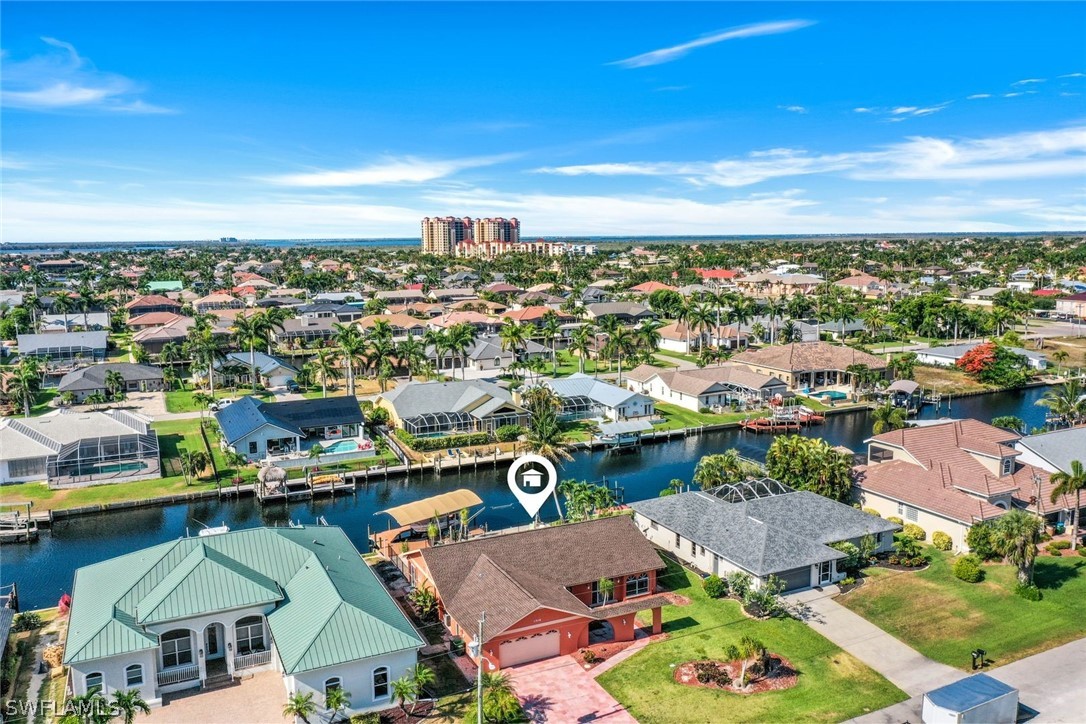 an aerial view of a city with lots of residential buildings ocean and mountain view in back