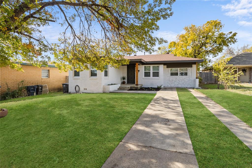 a front view of a house with a yard and trees