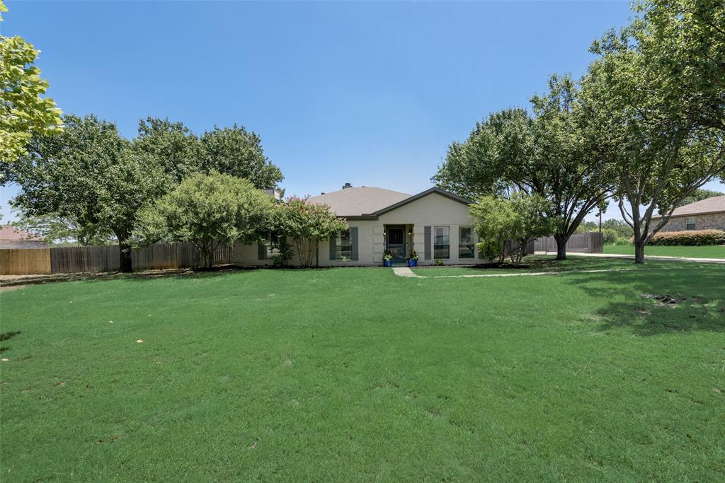 a front view of house with a garden and trees