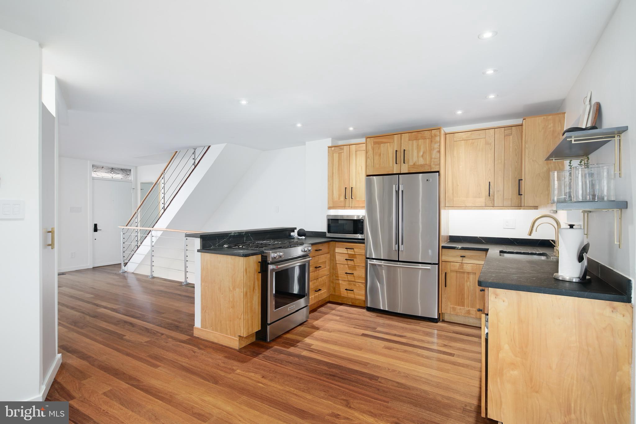 a kitchen with wooden floors and stainless steel appliances