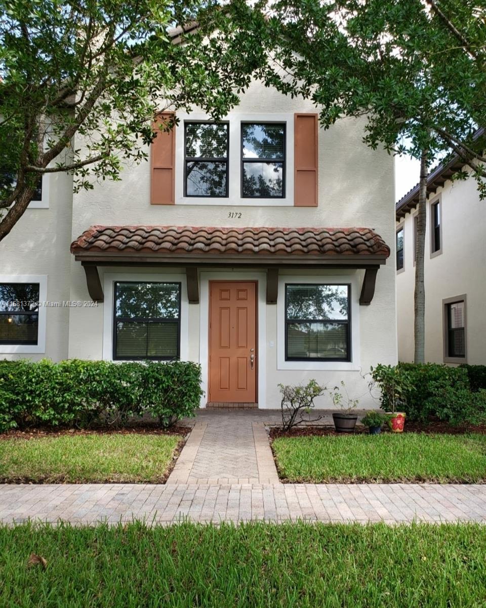 a front view of a house with a garden and plants