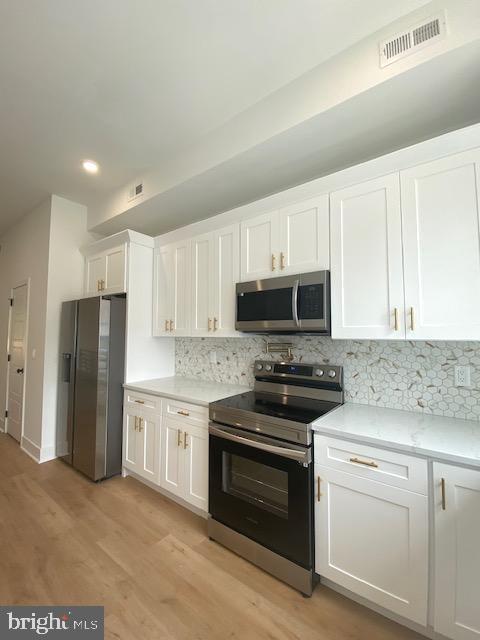 a kitchen with stainless steel appliances white cabinets and a stove