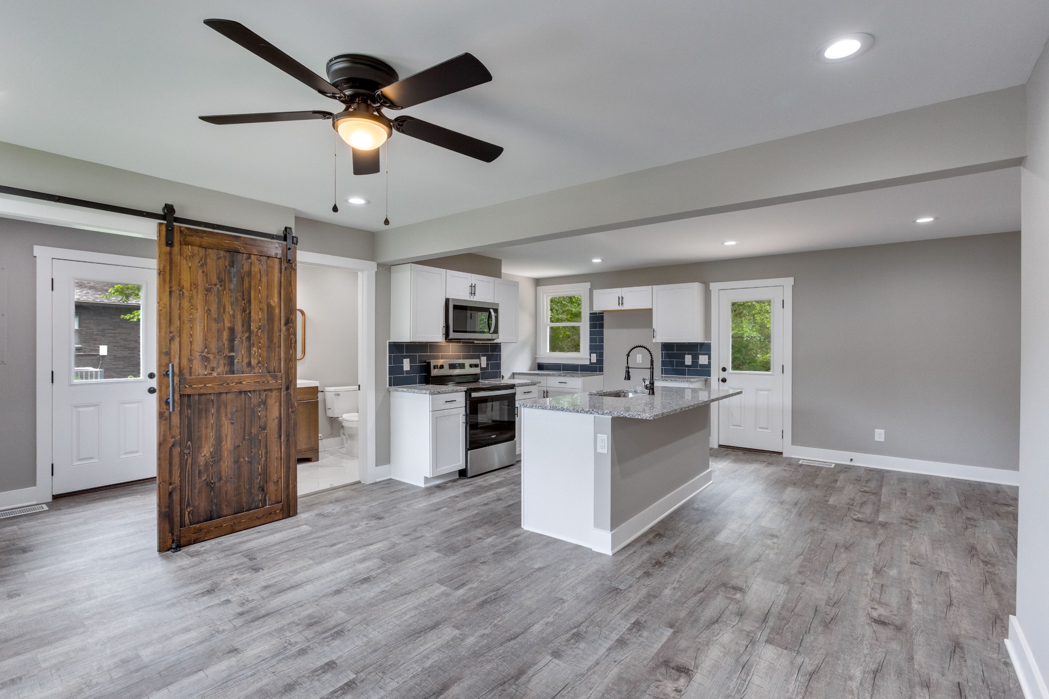 a kitchen with sink a refrigerator and microwave