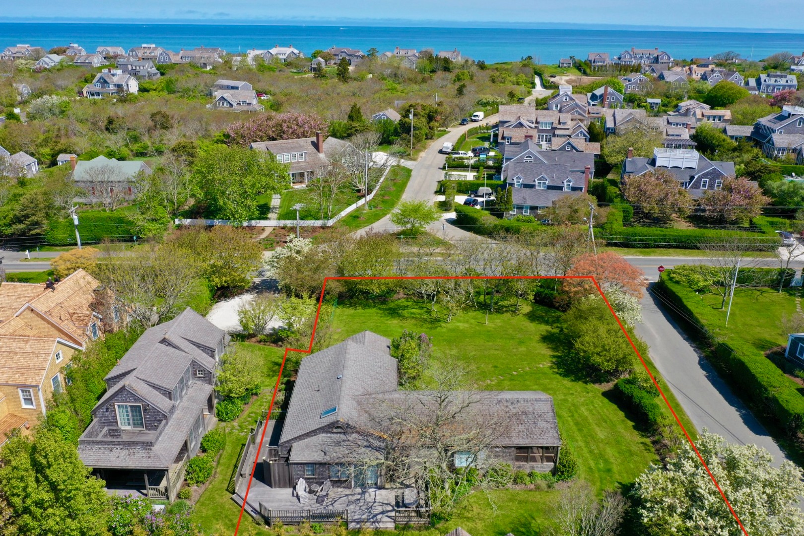 an aerial view of residential houses with outdoor space and lake view