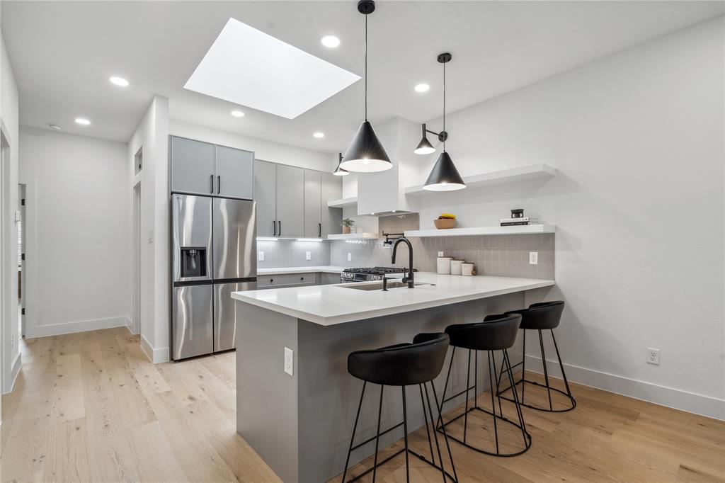 a kitchen with stainless steel appliances a sink and a refrigerator