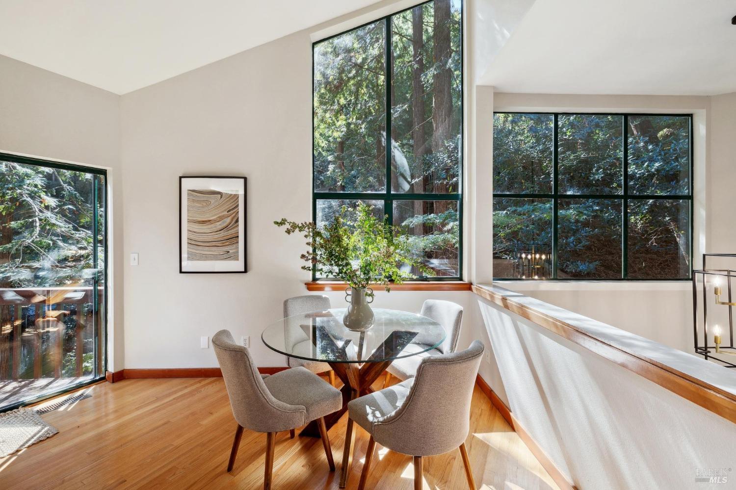 a dining room with furniture and large windows