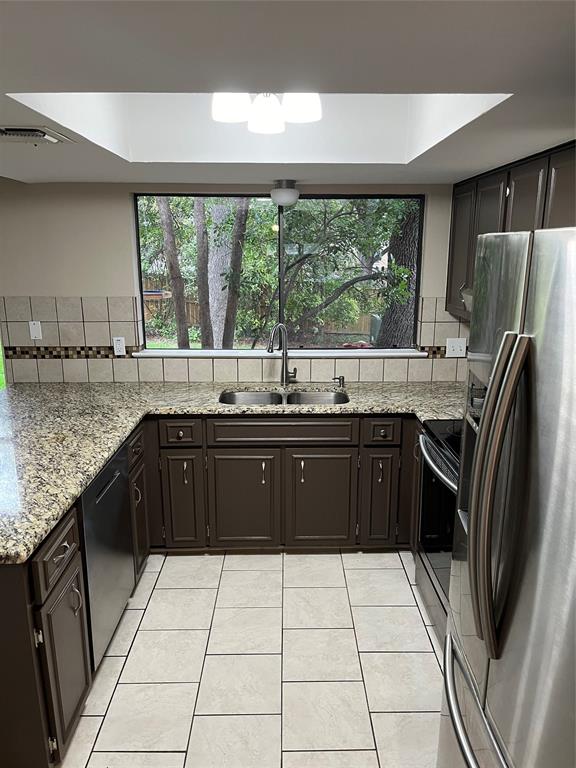 a kitchen with a sink a counter top space and stainless steel appliances