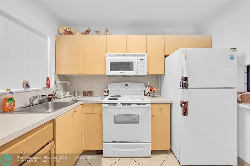 a view of a kitchen with a sink stove and refrigerator