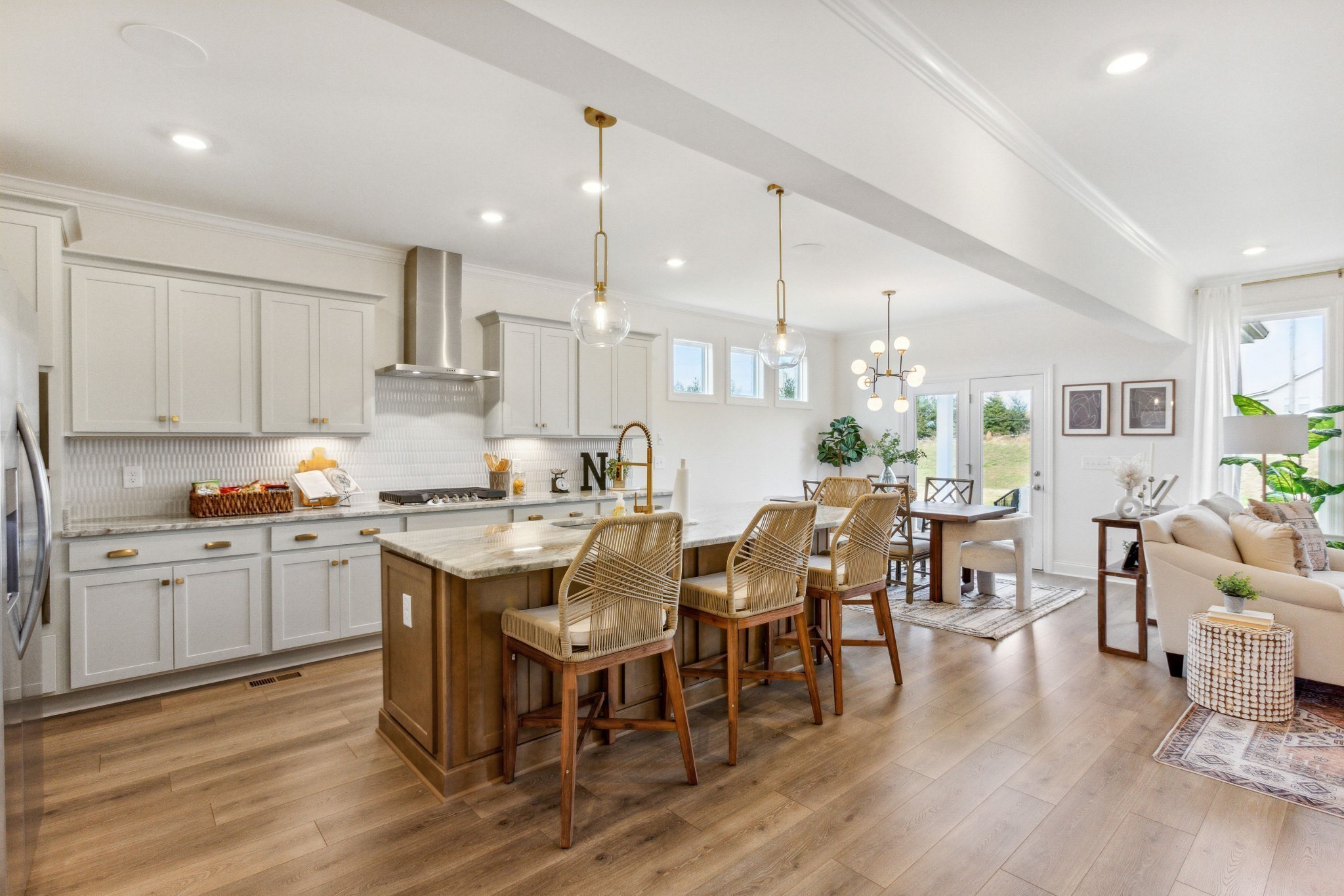 a kitchen with lots of white furniture appliances and wooden floor