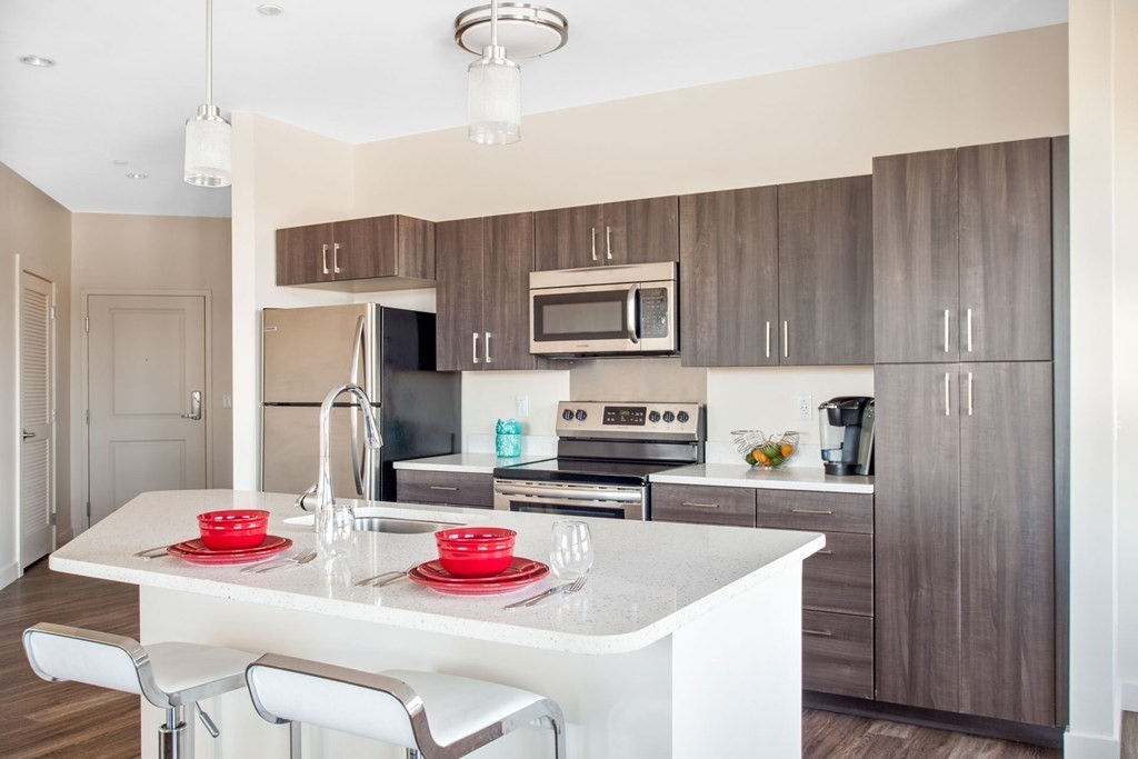 a kitchen with stainless steel appliances granite countertop a sink refrigerator and cabinets