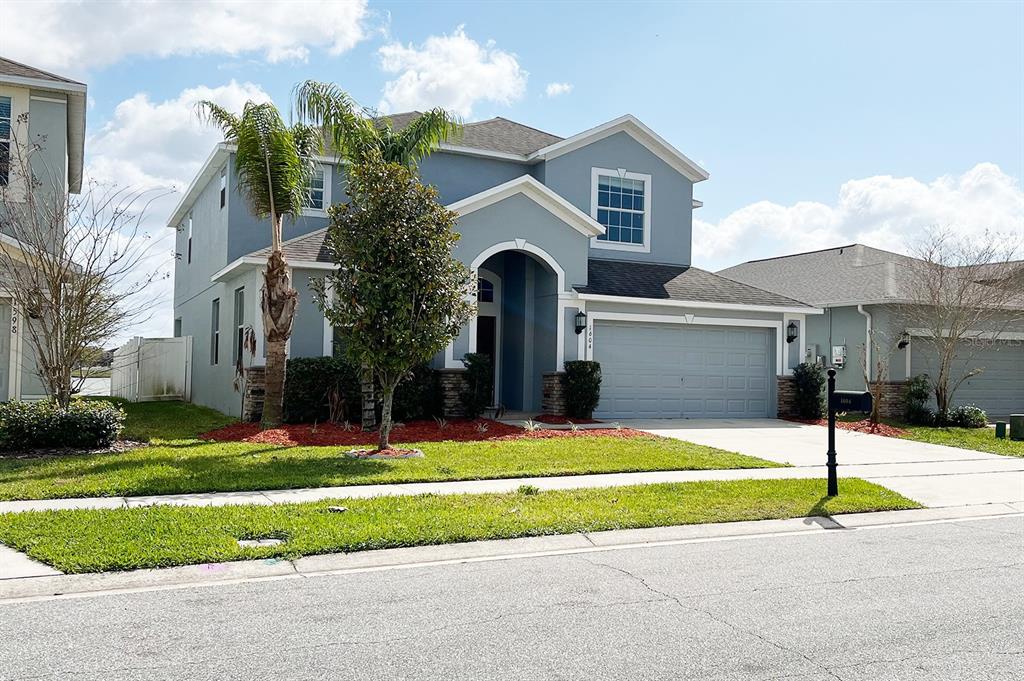 a front view of a house with a yard and garage