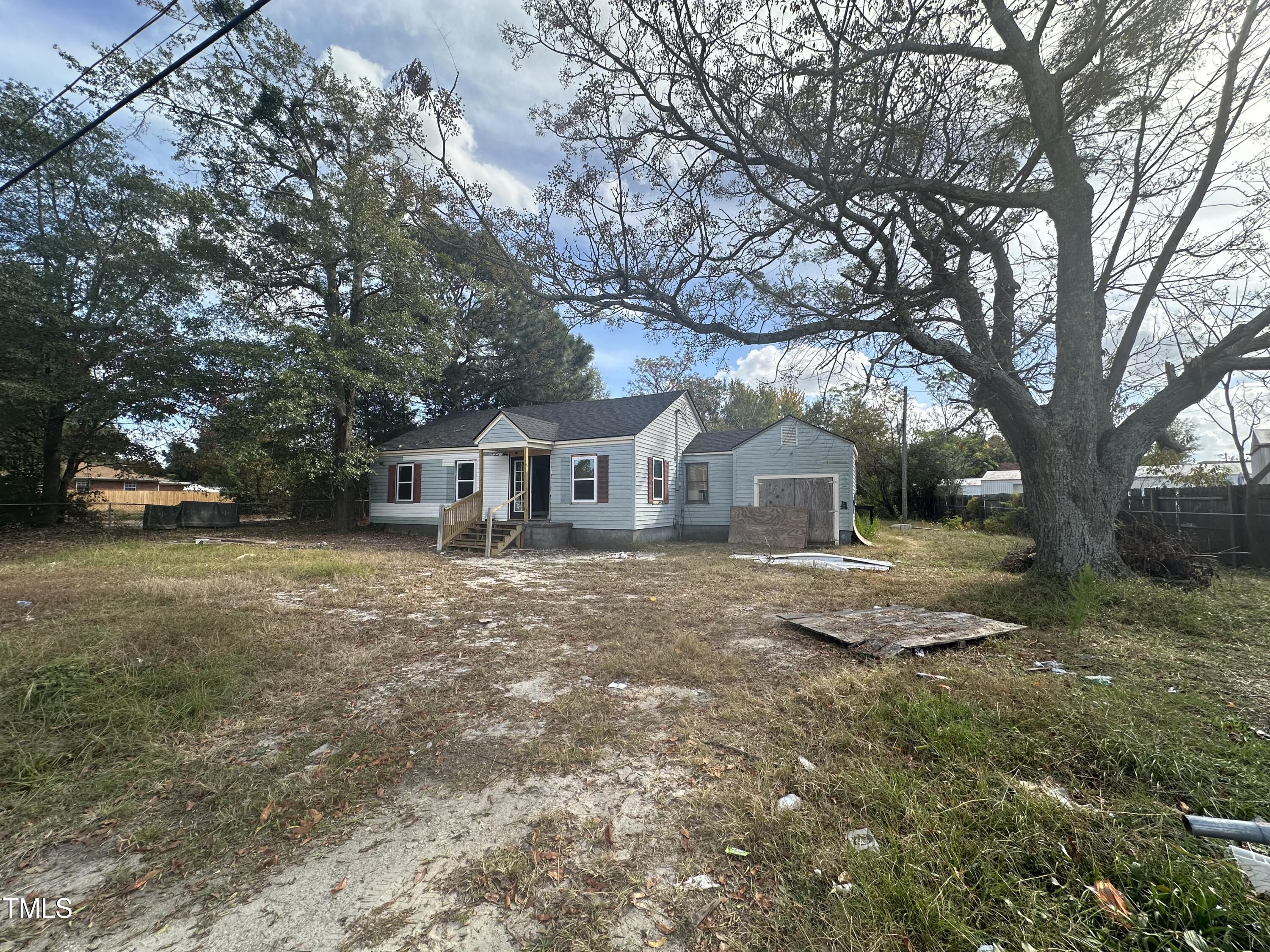 a front view of a house with a yard and trees