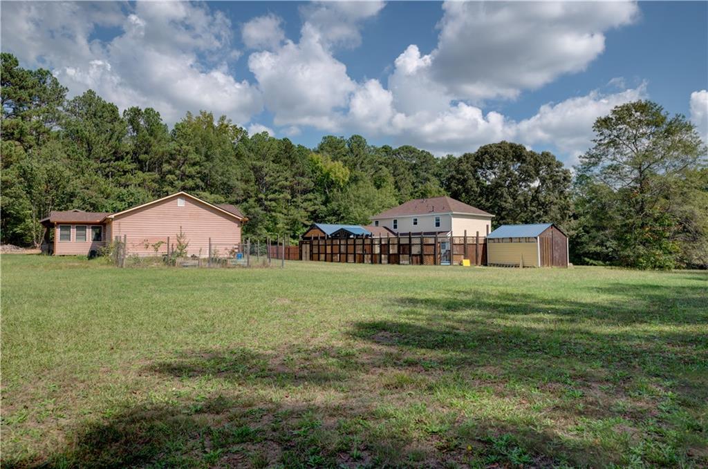 a view of a house with a big yard and a large trees