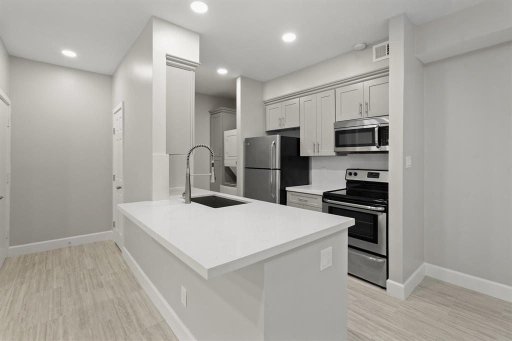 a kitchen with stainless steel appliances a refrigerator and a stove top oven