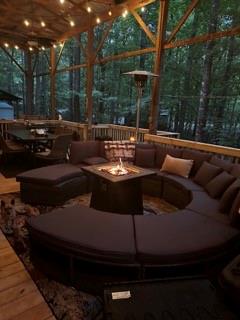 a view of patio with couches and a fire pit and wooden fence