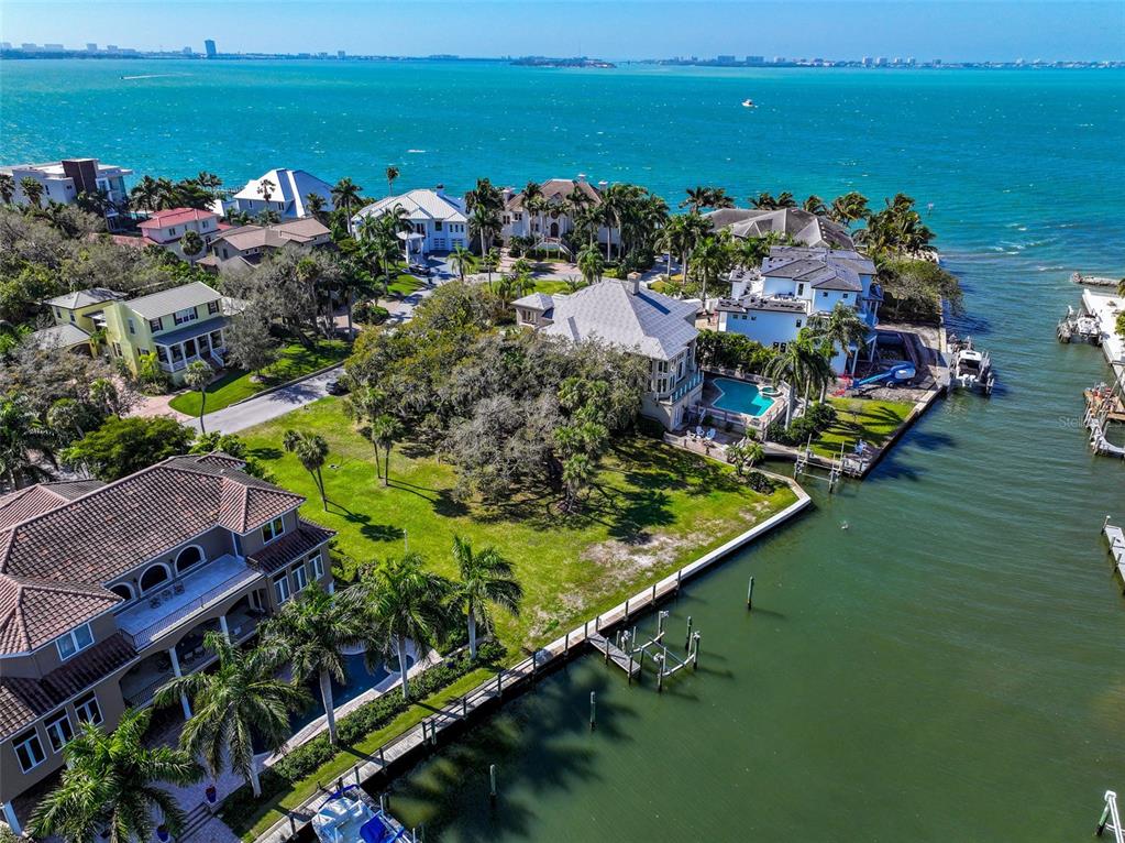 an aerial view of ocean and residential houses with outdoor space