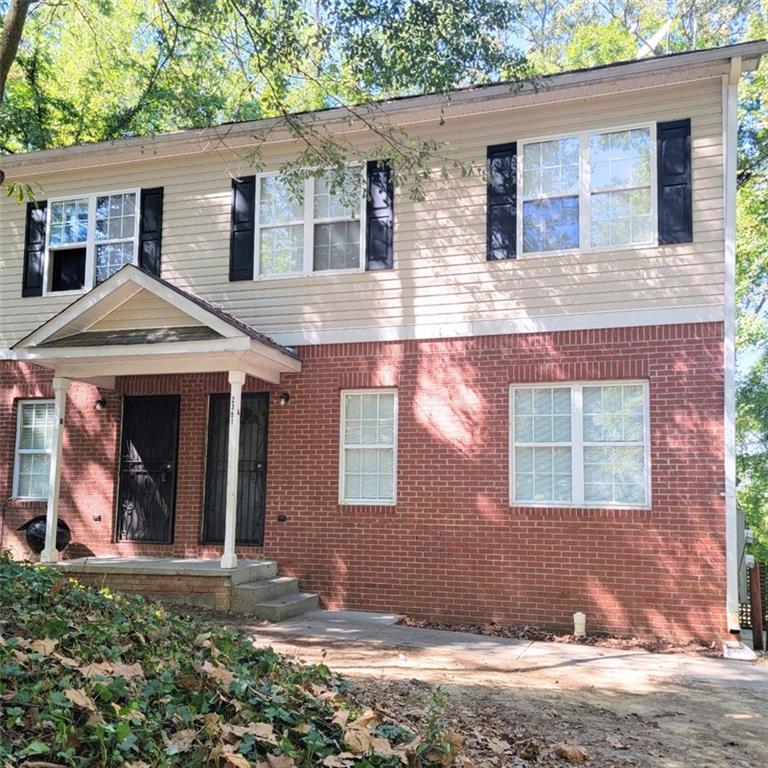 a view of a brick house with a yard