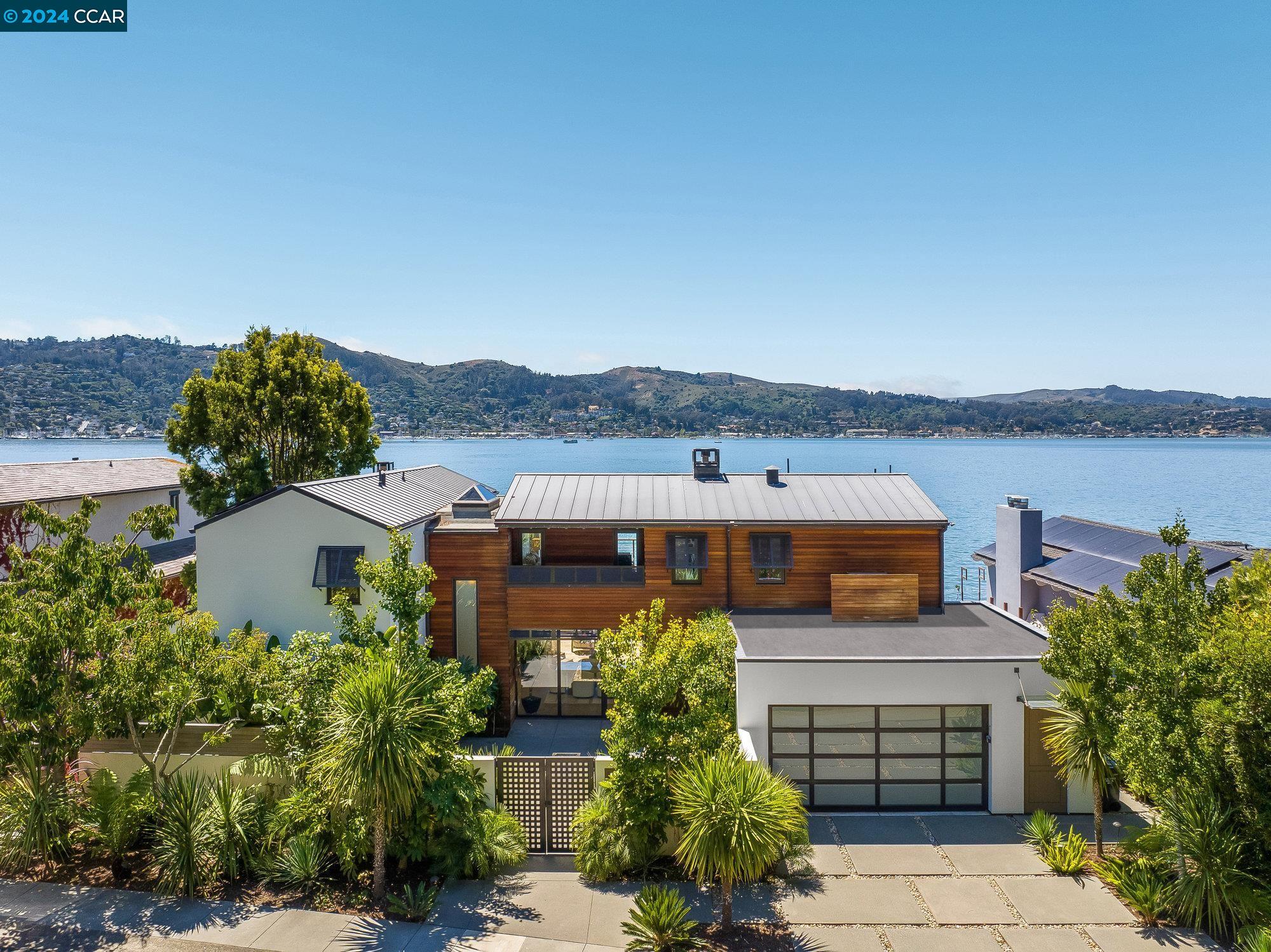 a front view of a house with a yard and lake view