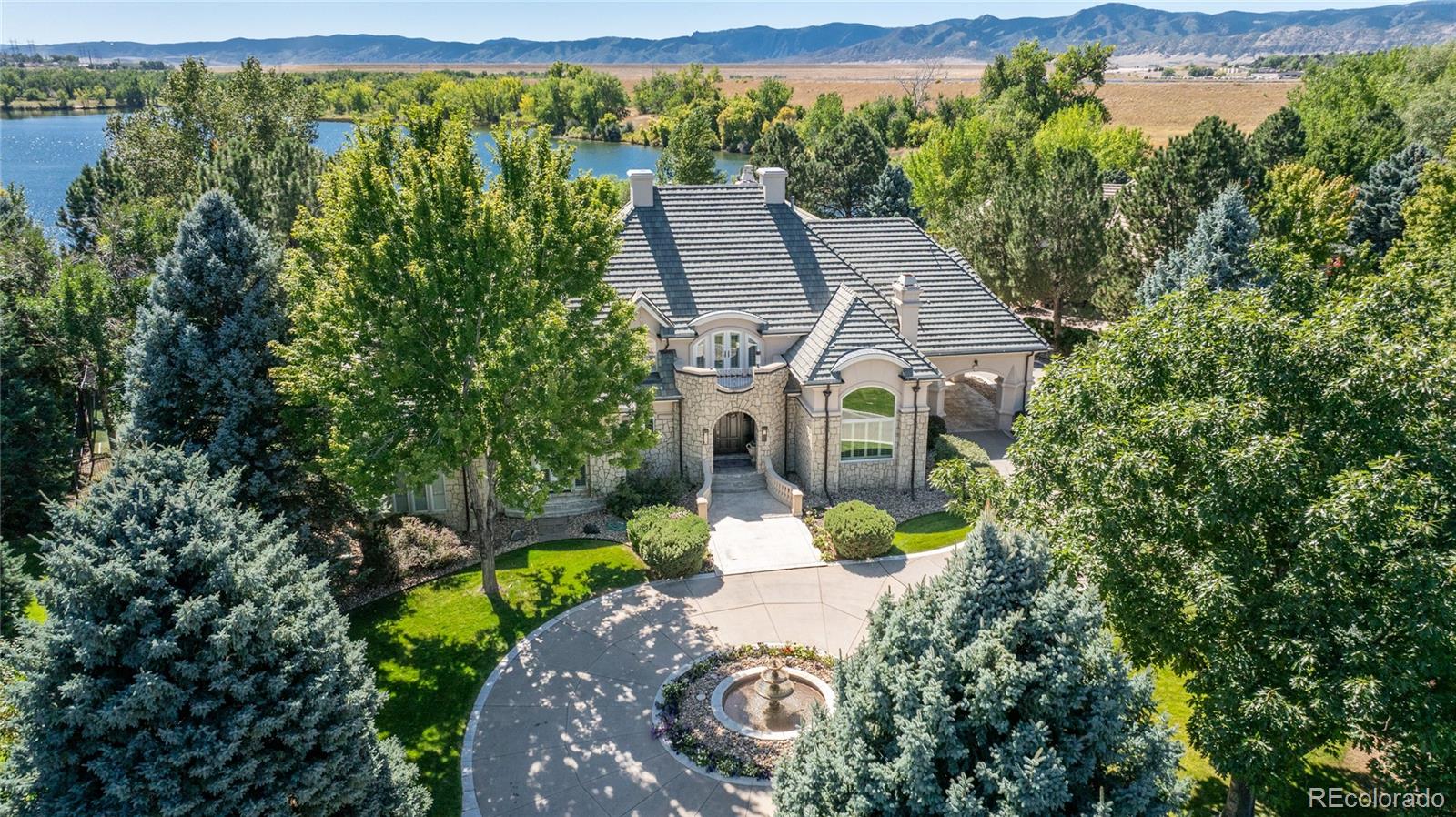 an aerial view of a house with a yard and lake view