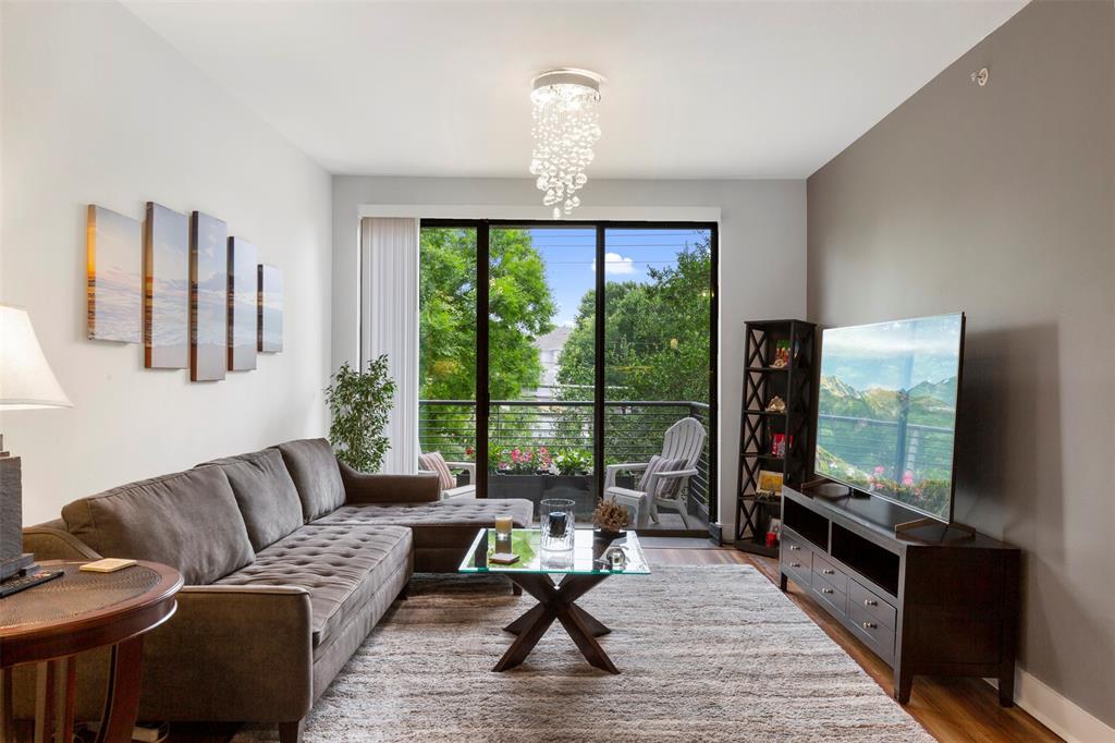 a living room with furniture a floor to ceiling window and a flat screen tv