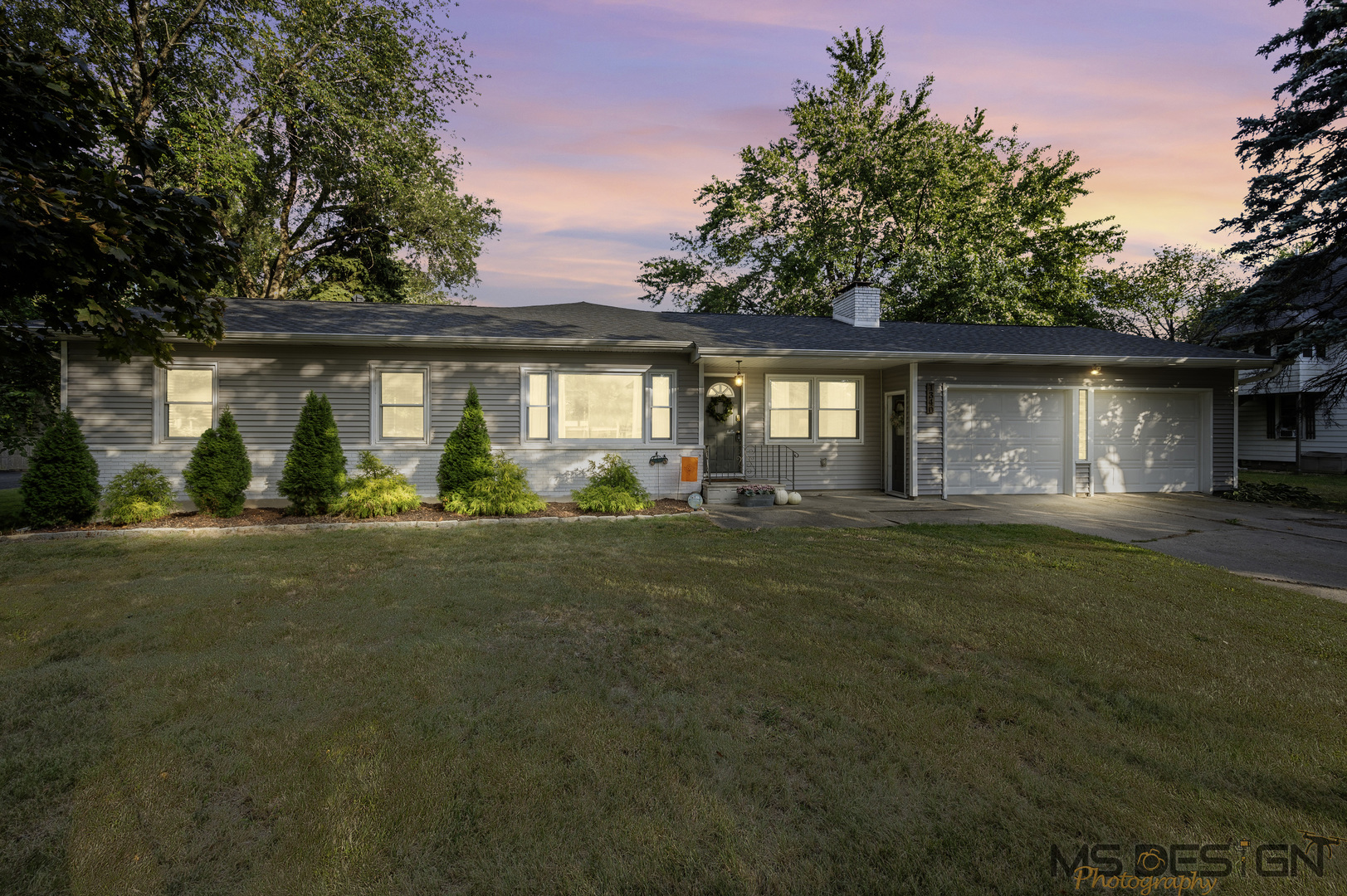 a front view of a house with a garden and yard