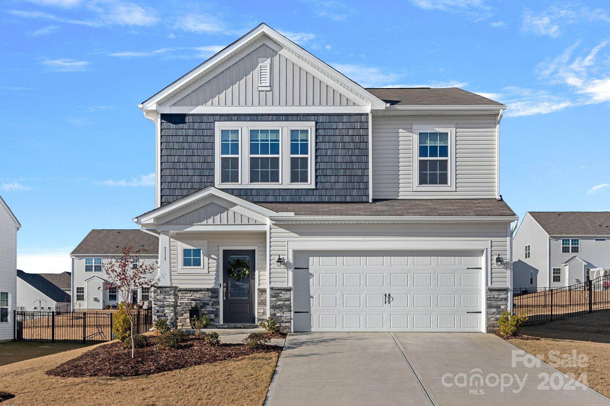 a front view of a house with yard and parking