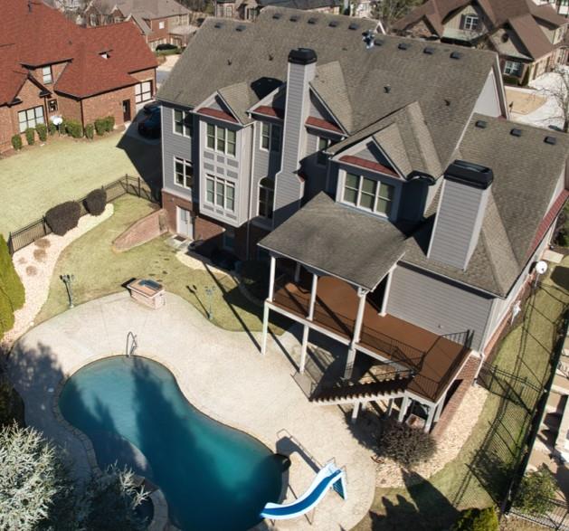 an aerial view of a house with backyard space and deck