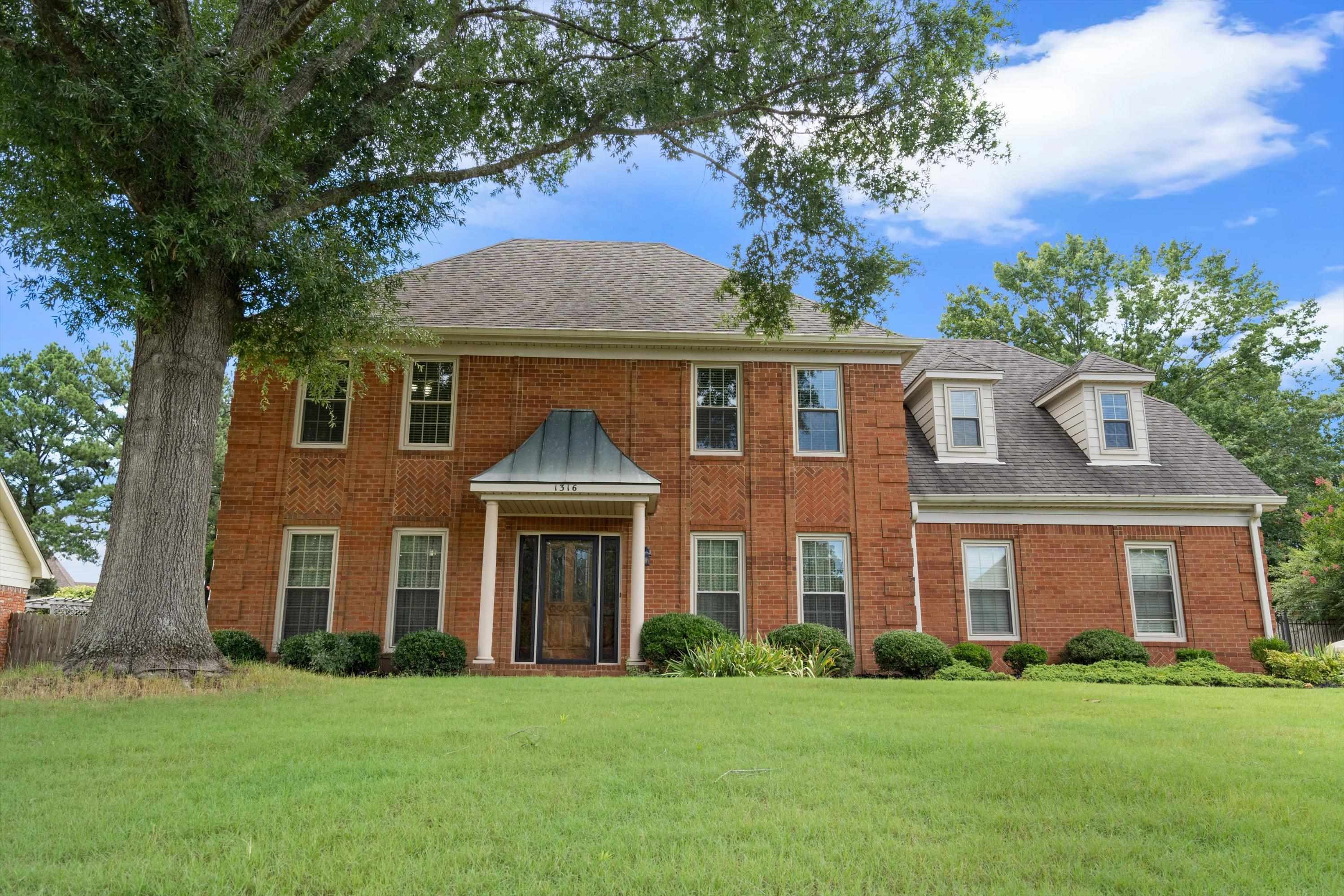 Colonial-style house featuring a front lawn