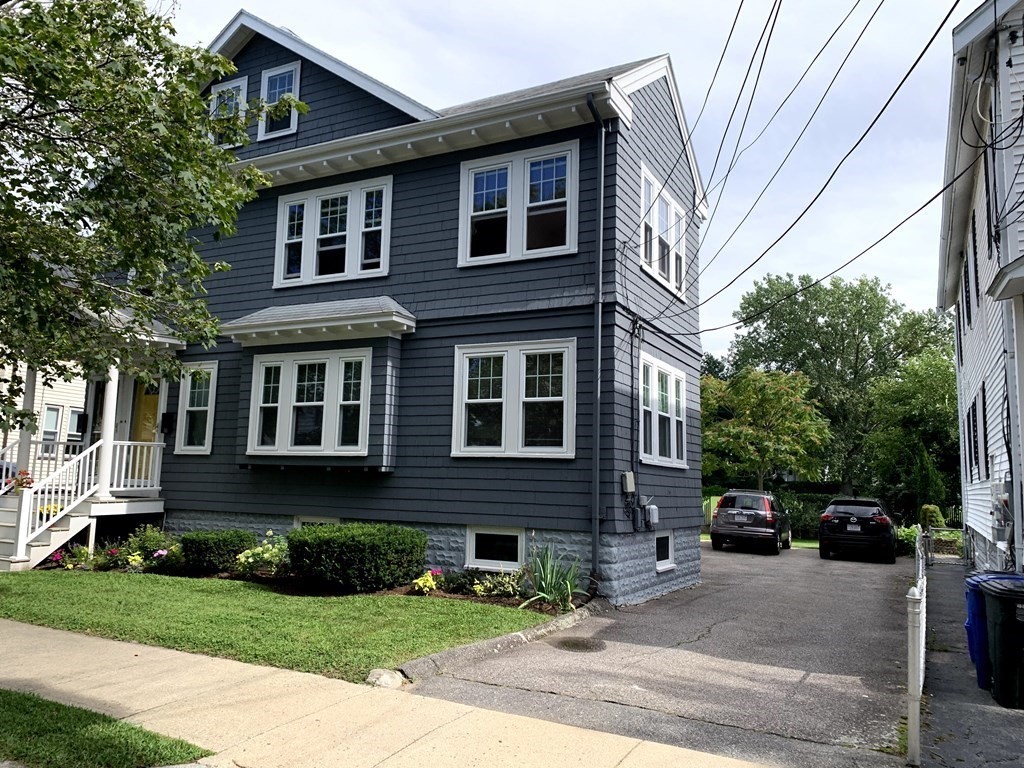 a front view of a house with yard and green space