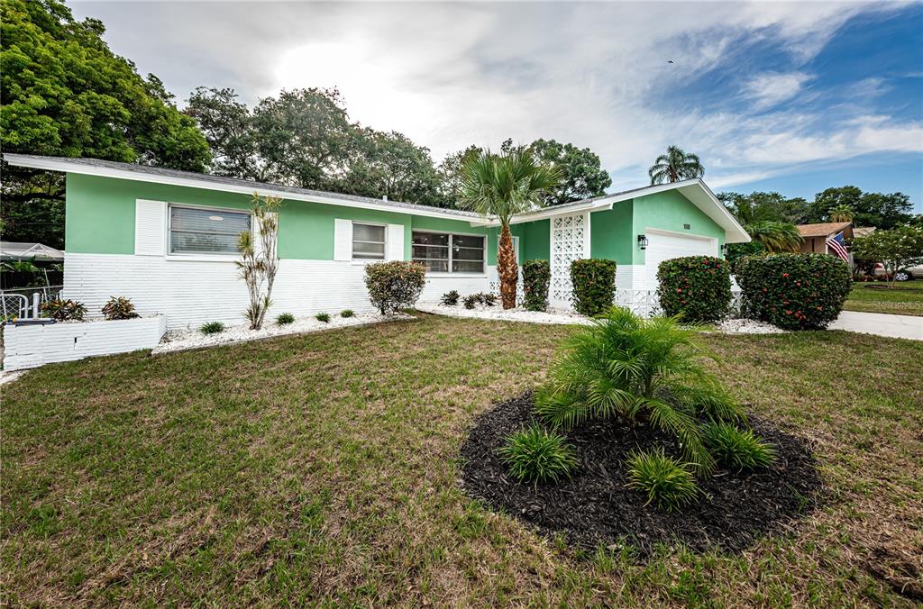 a front view of house with yard and trees in the background