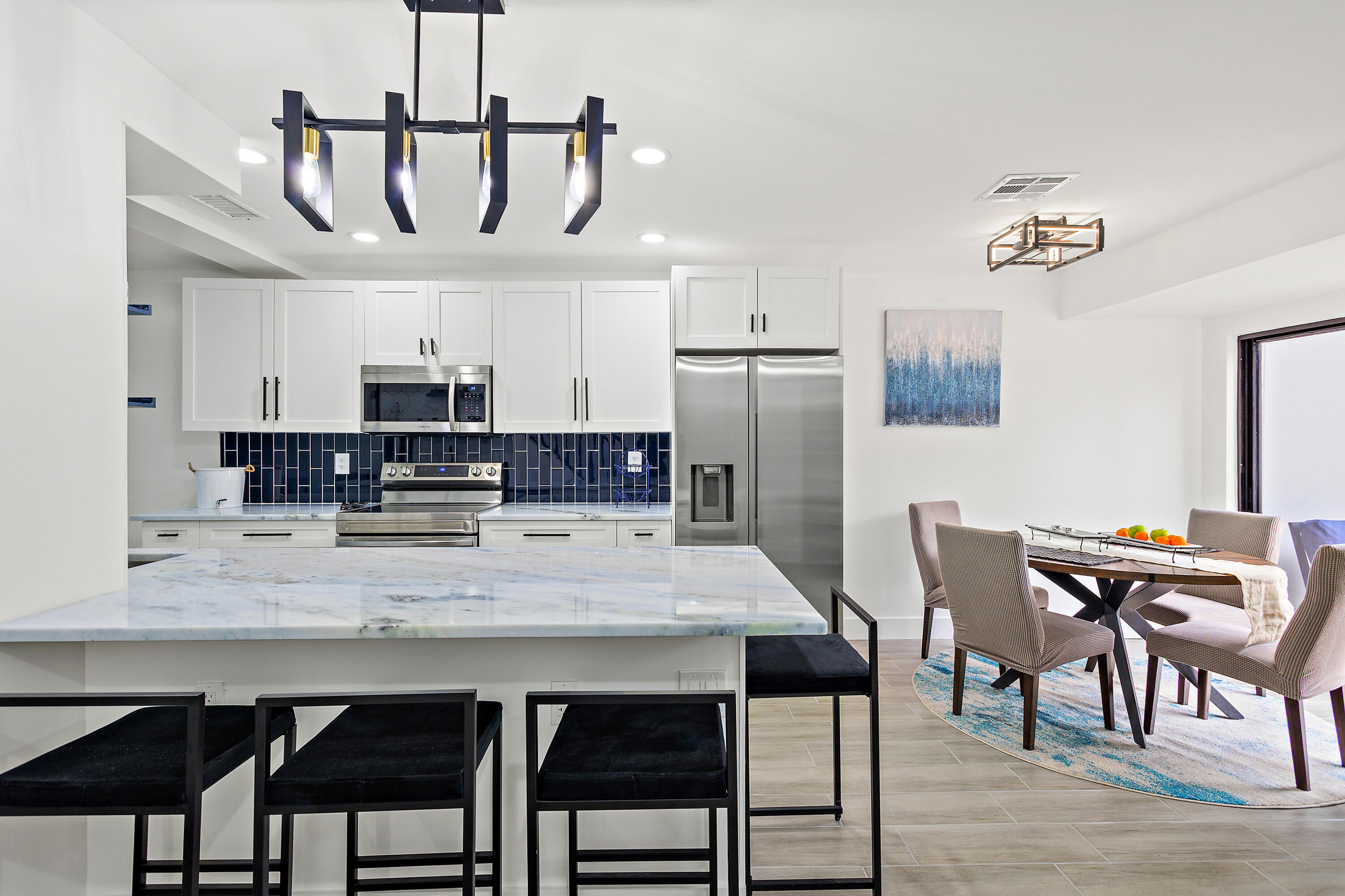 a view of kitchen with stainless steel appliances cabinets table and chairs