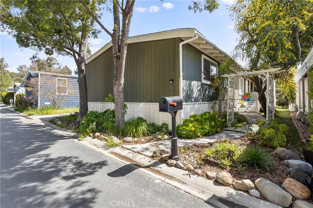 a front view of a house with garden and plants