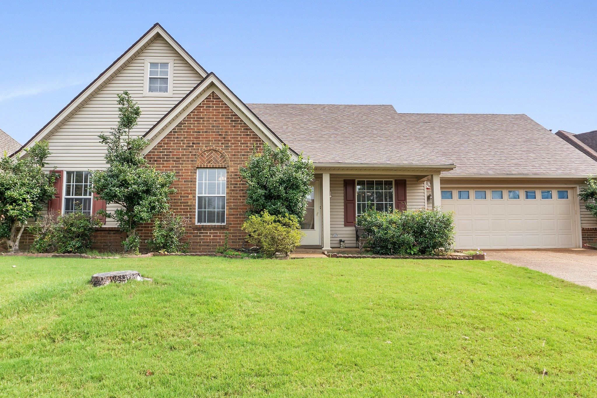 a front view of a house with yard and green space