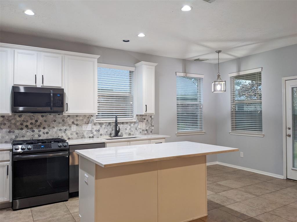 a kitchen with stainless steel appliances kitchen island granite countertop a stove and a sink