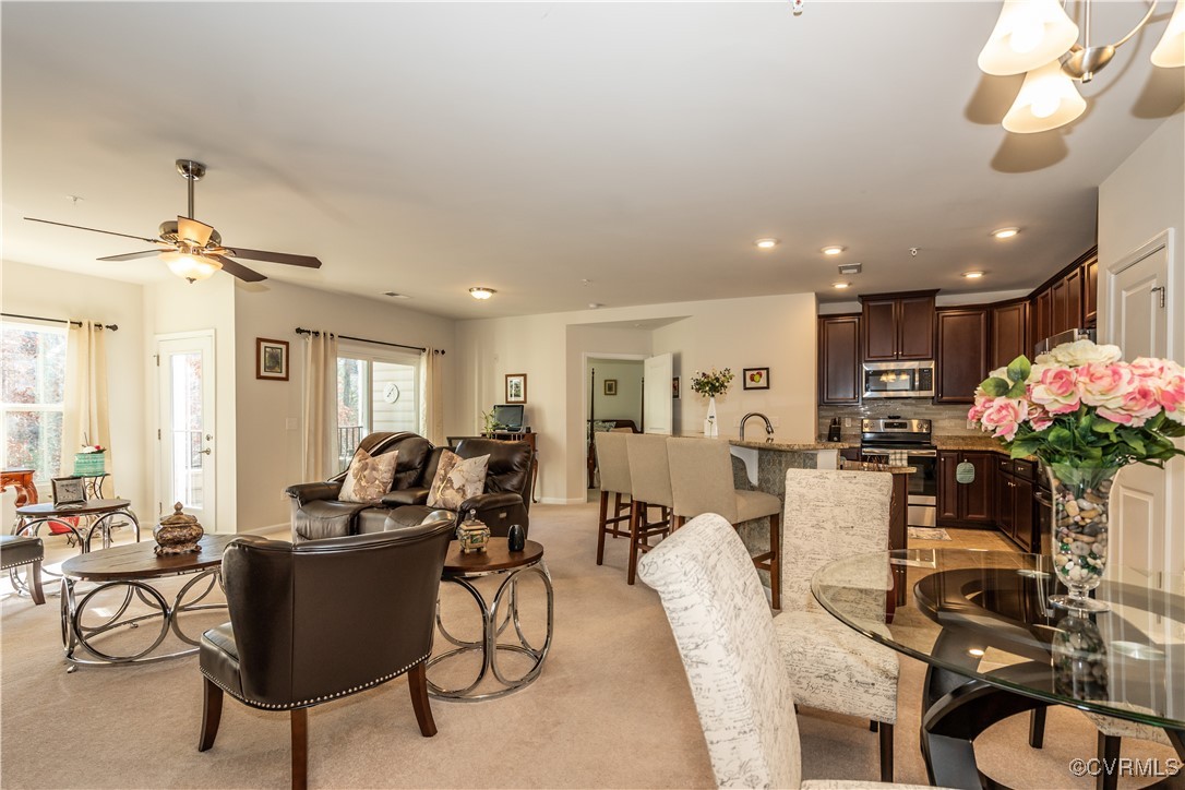 a living room with furniture a dining table and a potted plant