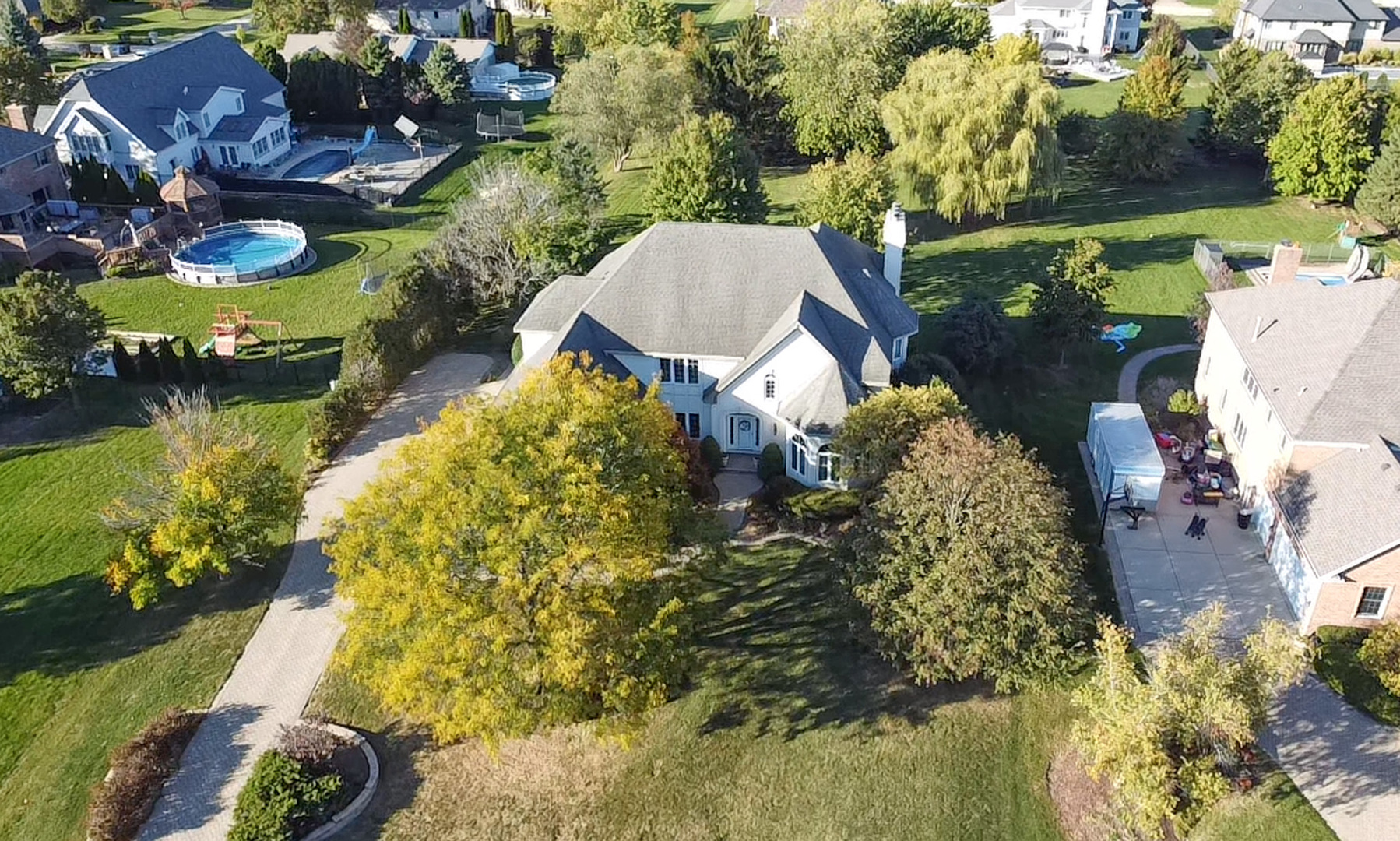 an aerial view of a house with a garden and lake view