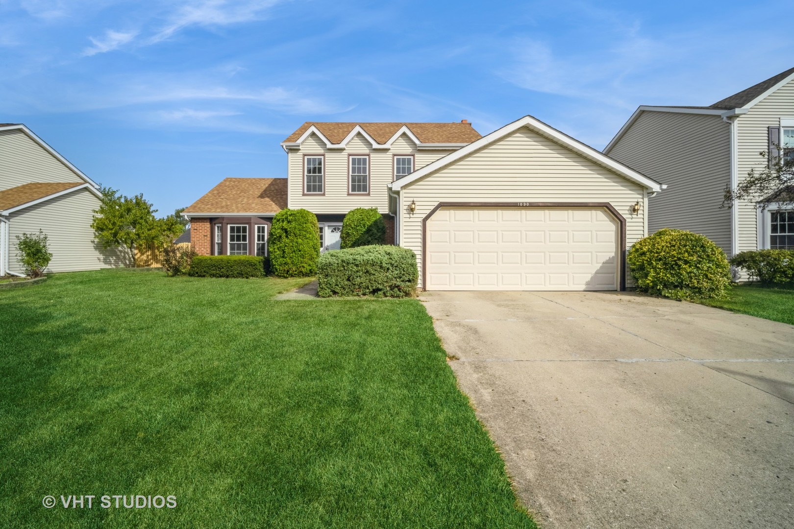 a front view of a house with a yard and garage